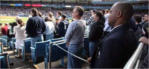 Photo of Yankee Stadium security guards chaining in fans for God Bless America